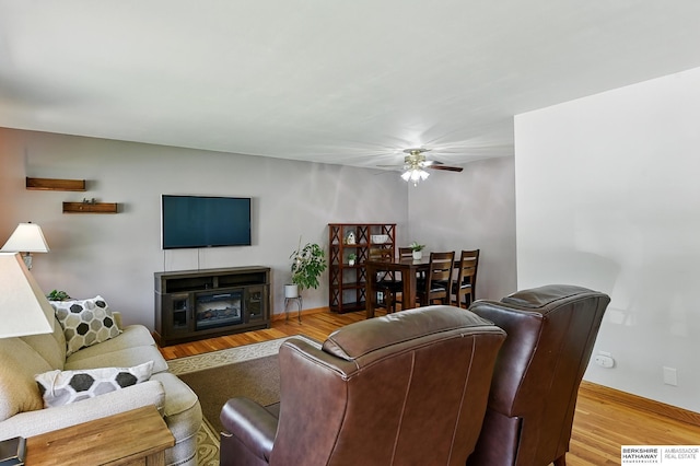 8345 Burt St, Omaha, NE 68114 - living room featuring a ceiling fan, wood finished floors, and a glass covered fireplace