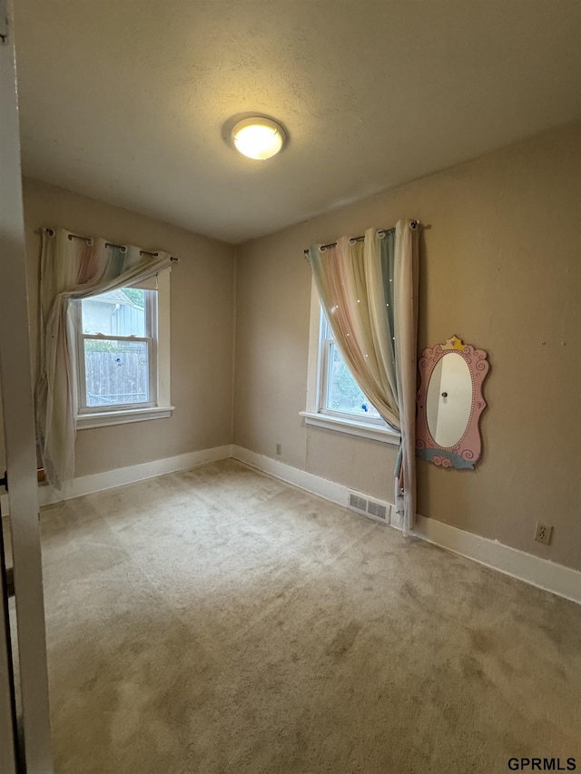 6035 Woolworth Ave, Omaha, NE 68106 - unfurnished room featuring carpet, baseboards, and a textured ceiling