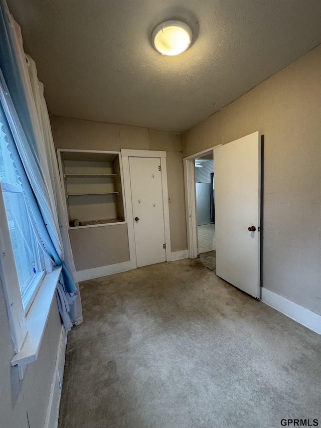6035 Woolworth Ave, Omaha, NE 68106 - unfurnished bedroom with carpet flooring, a textured ceiling, and baseboards