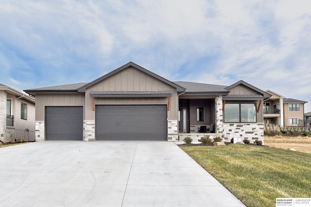 5807 N Hws Cleveland Blvd, Omaha, NE 68116 - view of front of home featuring board and batten siding, an attached garage, concrete driveway, a front lawn, and stone siding