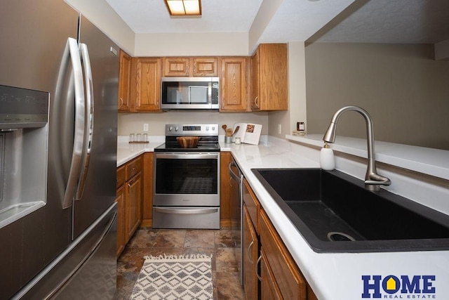 6207 Benjamin Pl, Lincoln, NE 68516 - kitchen featuring appliances with stainless steel finishes, a sink, brown cabinets, and light countertops