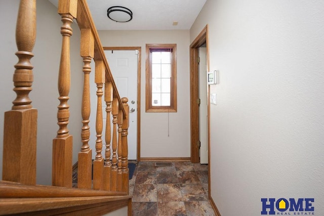 6207 Benjamin Pl, Lincoln, NE 68516 - doorway featuring baseboards, dark stone finish floors, and stairs