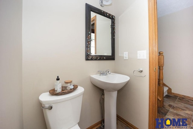 6207 Benjamin Pl, Lincoln, NE 68516 - bathroom featuring stone finish floors, toilet, baseboards, and a sink