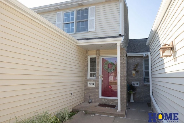 6207 Benjamin Pl, Lincoln, NE 68516 - view of exterior entry featuring brick siding and roof with shingles