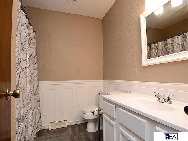 2103 Randall Dr, Bellevue, NE 68005 - full bathroom featuring vanity, a wainscoted wall, wood finished floors, and toilet