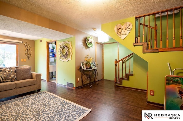 5431 S 48th Ave, Omaha, NE 68117 - living room with wood finished floors, a textured ceiling, stairway, and baseboards