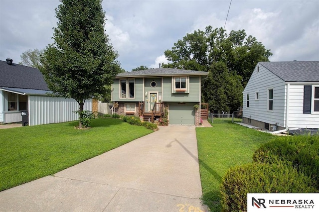 5431 S 48th Ave, Omaha, NE 68117 - bi-level home with concrete driveway, an attached garage, a front lawn, and brick siding