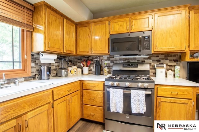 5431 S 48th Ave, Omaha, NE 68117 - kitchen featuring appliances with stainless steel finishes, light countertops, tasteful backsplash, and wood finished floors