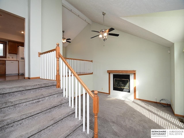 15211 Pasadena Ave, Omaha, NE 68144 - stairs with a ceiling fan, beamed ceiling, a tiled fireplace, high vaulted ceiling, and carpet floors