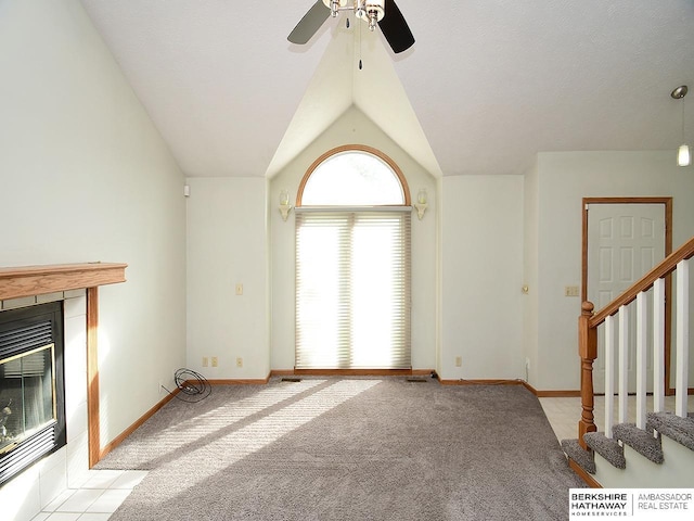 15211 Pasadena Ave, Omaha, NE 68144 - unfurnished living room featuring ceiling fan, carpet floors, stairs, vaulted ceiling, and a tile fireplace