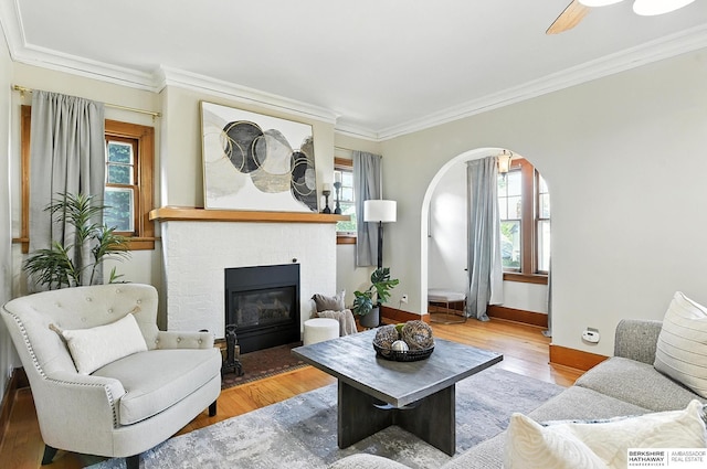 2311 N 51st St, Omaha, NE 68104 - living area with plenty of natural light, arched walkways, ornamental molding, wood finished floors, and a fireplace with flush hearth