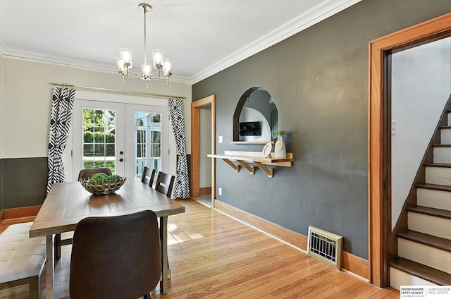 2311 N 51st St, Omaha, NE 68104 - dining space featuring a chandelier, crown molding, stairs, light wood-type flooring, and french doors