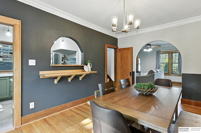 2311 N 51st St, Omaha, NE 68104 - dining room featuring arched walkways, a chandelier, wood finished floors, crown molding, and a ceiling fan