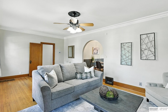 2311 N 51st St, Omaha, NE 68104 - living room featuring arched walkways, a ceiling fan, crown molding, and light wood-style floors