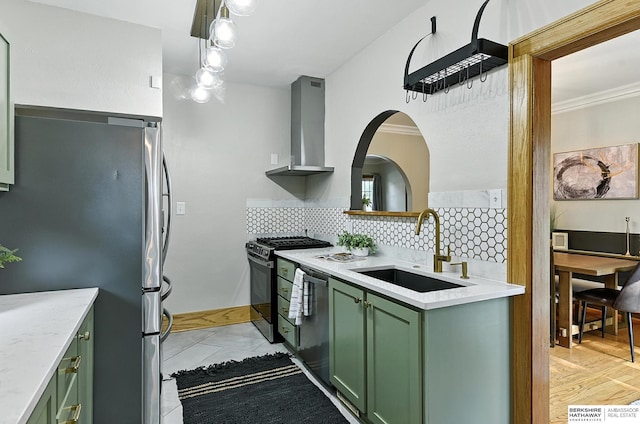 2311 N 51st St, Omaha, NE 68104 - kitchen with green cabinetry, stainless steel appliances, wall chimney exhaust hood, decorative backsplash, and light marble finish flooring