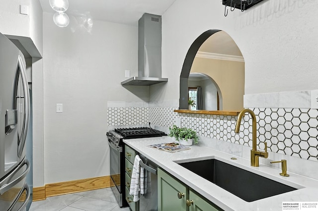 2311 N 51st St, Omaha, NE 68104 - kitchen featuring stainless steel appliances, wall chimney exhaust hood, green cabinetry, decorative backsplash, and crown molding
