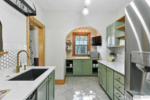 2311 N 51st St, Omaha, NE 68104 - kitchen with green cabinetry, open shelves, appliances with stainless steel finishes, arched walkways, and decorative backsplash