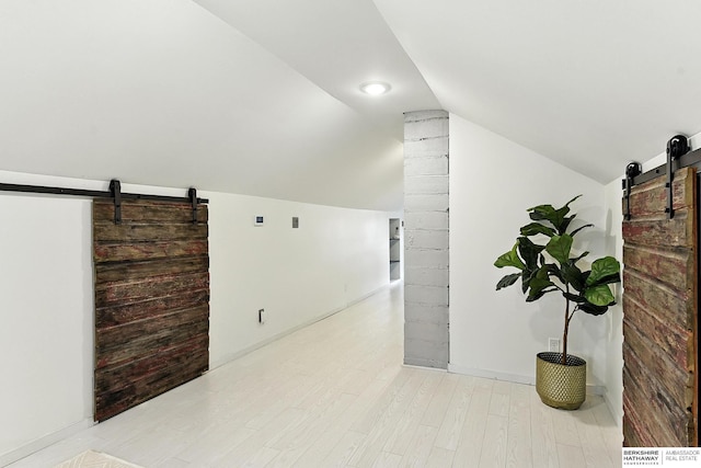 2311 N 51st St, Omaha, NE 68104 - unfurnished room with a barn door, vaulted ceiling, and light wood-style floors