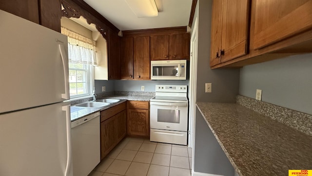 1506 E 1st St, Fremont, NE 68025 - kitchen featuring white appliances, a sink, light tile patterned floors, and brown cabinets