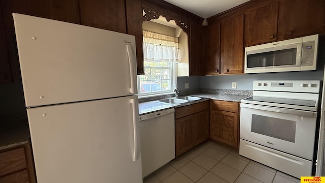 1506 E 1st St, Fremont, NE 68025 - kitchen with white appliances, light tile patterned floors, and a sink