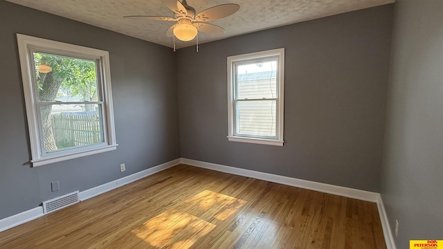 1506 E 1st St, Fremont, NE 68025 - unfurnished room featuring baseboards, light wood finished floors, ceiling fan, and a textured ceiling