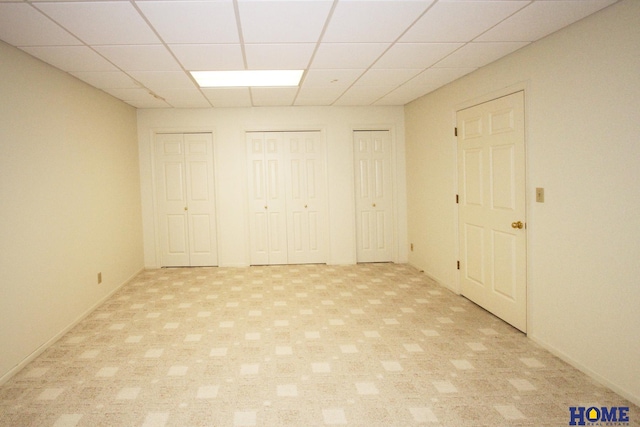 6427 Lone Tree Dr, Lincoln, NE 68512 - unfurnished bedroom with two closets, a drop ceiling, and light carpet