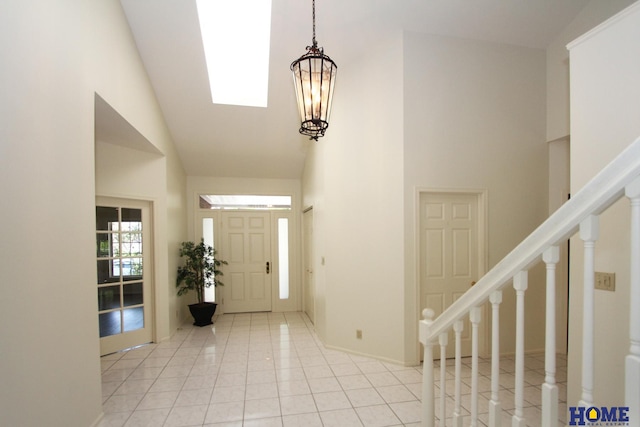 6427 Lone Tree Dr, Lincoln, NE 68512 - entrance foyer with high vaulted ceiling, stairs, light tile patterned floors, a chandelier, and baseboards