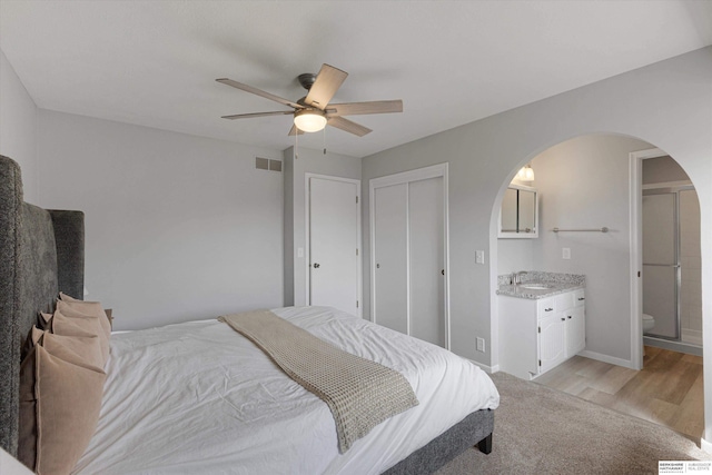 2629 N 129th Cir, Omaha, NE 68164 - bedroom with a sink, arched walkways, light wood finished floors, ceiling fan, and ensuite bath