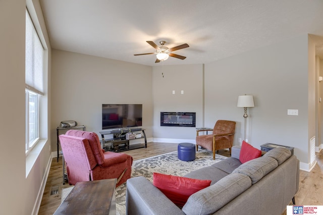 1637 W Avalanche Rd, Lincoln, NE 68521 - living room featuring a ceiling fan, light wood-type flooring, and a glass covered fireplace