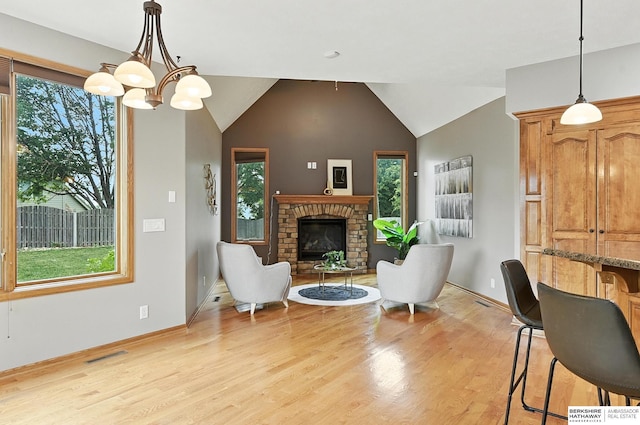 5418 S 165th St, Omaha, NE 68135 - living area with light wood-style floors, a brick fireplace, lofted ceiling, and a chandelier