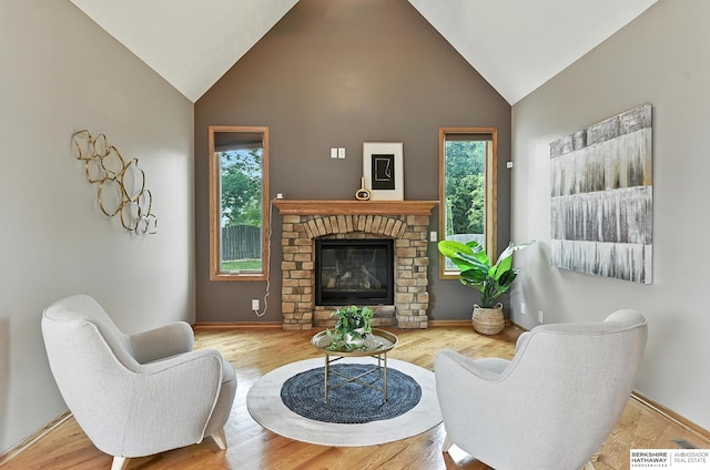 5418 S 165th St, Omaha, NE 68135 - living area featuring high vaulted ceiling, a brick fireplace, and wood finished floors