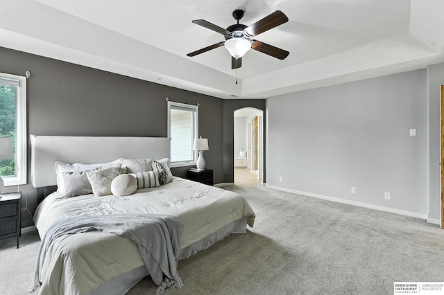 5418 S 165th St, Omaha, NE 68135 - carpeted bedroom featuring a tray ceiling, arched walkways, a ceiling fan, and ensuite bathroom