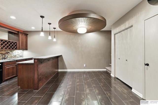 5418 S 165th St, Omaha, NE 68135 - kitchen with tasteful backsplash, hanging light fixtures, a peninsula, recessed lighting, and a kitchen bar