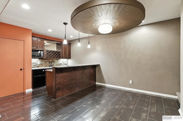 5418 S 165th St, Omaha, NE 68135 - indoor wet bar featuring black microwave, tasteful backsplash, recessed lighting, and hanging light fixtures