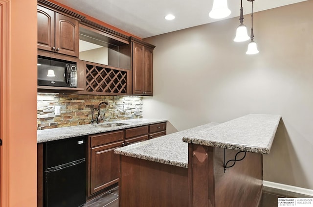 5418 S 165th St, Omaha, NE 68135 - indoor wet bar with black microwave, decorative backsplash, hanging light fixtures, and dark tile patterned flooring