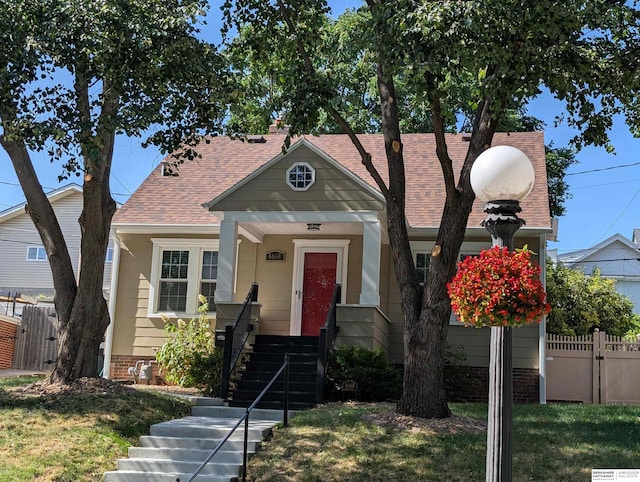 4668 Pine St, Omaha, NE 68106 - bungalow with a shingled roof, a gate, and brick siding
