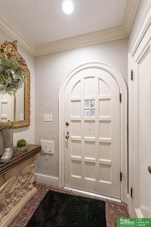 523 N 52nd St, Omaha, NE 68132 - foyer entrance featuring brick floors, a textured wall, crown molding, and arched walkways