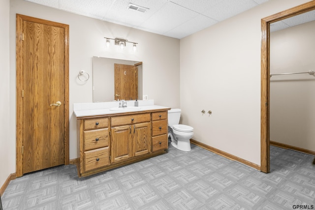759 Simms Ave, Council Bluffs, IA 51503 - bathroom featuring toilet, vanity, a drop ceiling, and baseboards