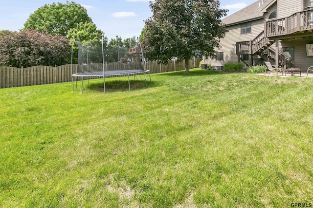 759 Simms Ave, Council Bluffs, IA 51503 - view of yard with a trampoline, stairway, and a wooden deck