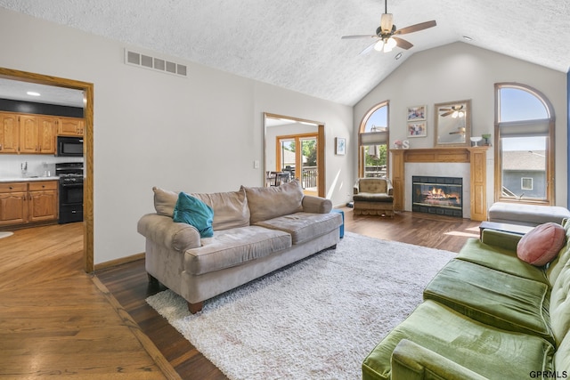 759 Simms Ave, Council Bluffs, IA 51503 - living area featuring plenty of natural light, a tile fireplace, a textured ceiling, lofted ceiling, and a ceiling fan
