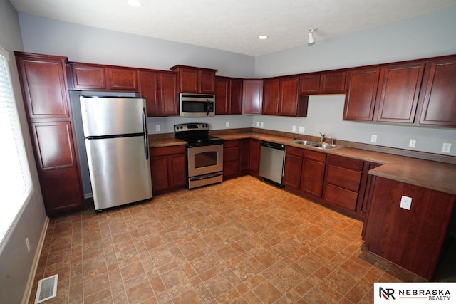 19122 Drexel St, Omaha, NE 68135 - kitchen featuring stainless steel appliances, recessed lighting, light floors, and reddish brown cabinets