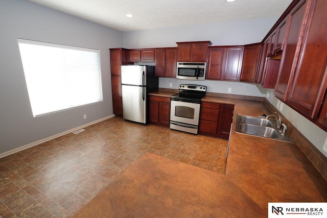 19122 Drexel St, Omaha, NE 68135 - kitchen with stainless steel appliances, recessed lighting, light flooring, and reddish brown cabinets