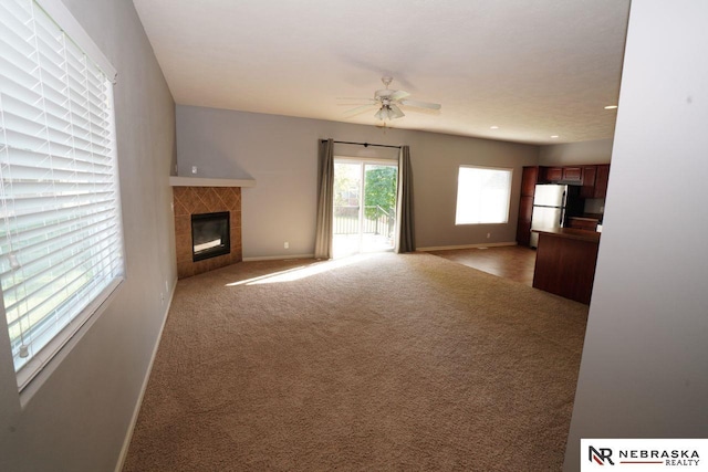 19122 Drexel St, Omaha, NE 68135 - unfurnished living room with a tiled fireplace, ceiling fan, carpet, and recessed lighting
