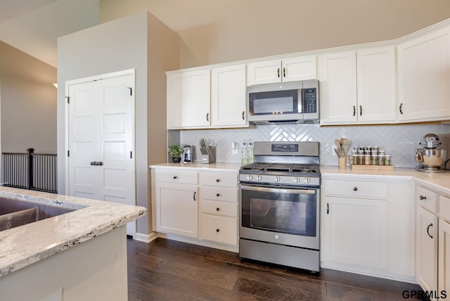 7810 S 184th Ave, Omaha, NE 68136 - kitchen with stainless steel appliances, dark wood-type flooring, tasteful backsplash, and white cabinetry