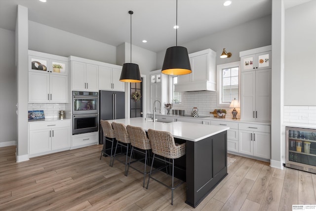 3307 S 209th St, Omaha, NE 68022 - kitchen featuring stainless steel double oven, black electric cooktop, backsplash, light countertops, and light wood finished floors
