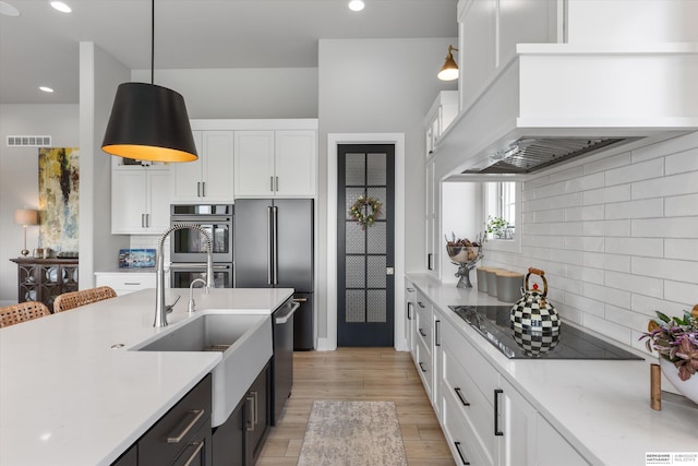 3307 S 209th St, Omaha, NE 68022 - kitchen with black electric stovetop, stainless steel dishwasher, white cabinetry, decorative backsplash, and recessed lighting