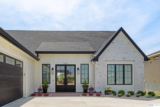 3307 S 209th St, Omaha, NE 68022 - property entrance featuring french doors, brick siding, driveway, and roof with shingles