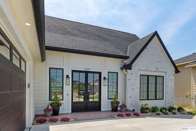 3307 S 209th St, Omaha, NE 68022 - property entrance featuring french doors, roof with shingles, and brick siding