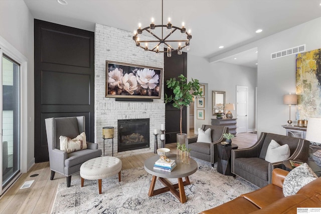 3307 S 209th St, Omaha, NE 68022 - living area featuring light wood-style flooring, a chandelier, a brick fireplace, and recessed lighting