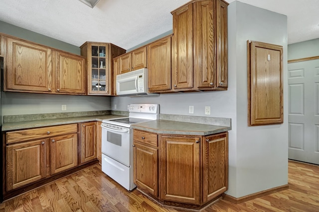 1035 Primrose Ln, Hickman, NE 68372 - kitchen featuring white appliances, light wood finished floors, brown cabinets, and a textured ceiling